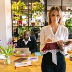 Diverse group of professionals collaborating in a greenery-filled modern office.